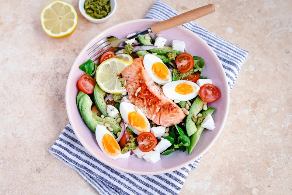 Salad with fried salmon, avocado & pesto dressing
